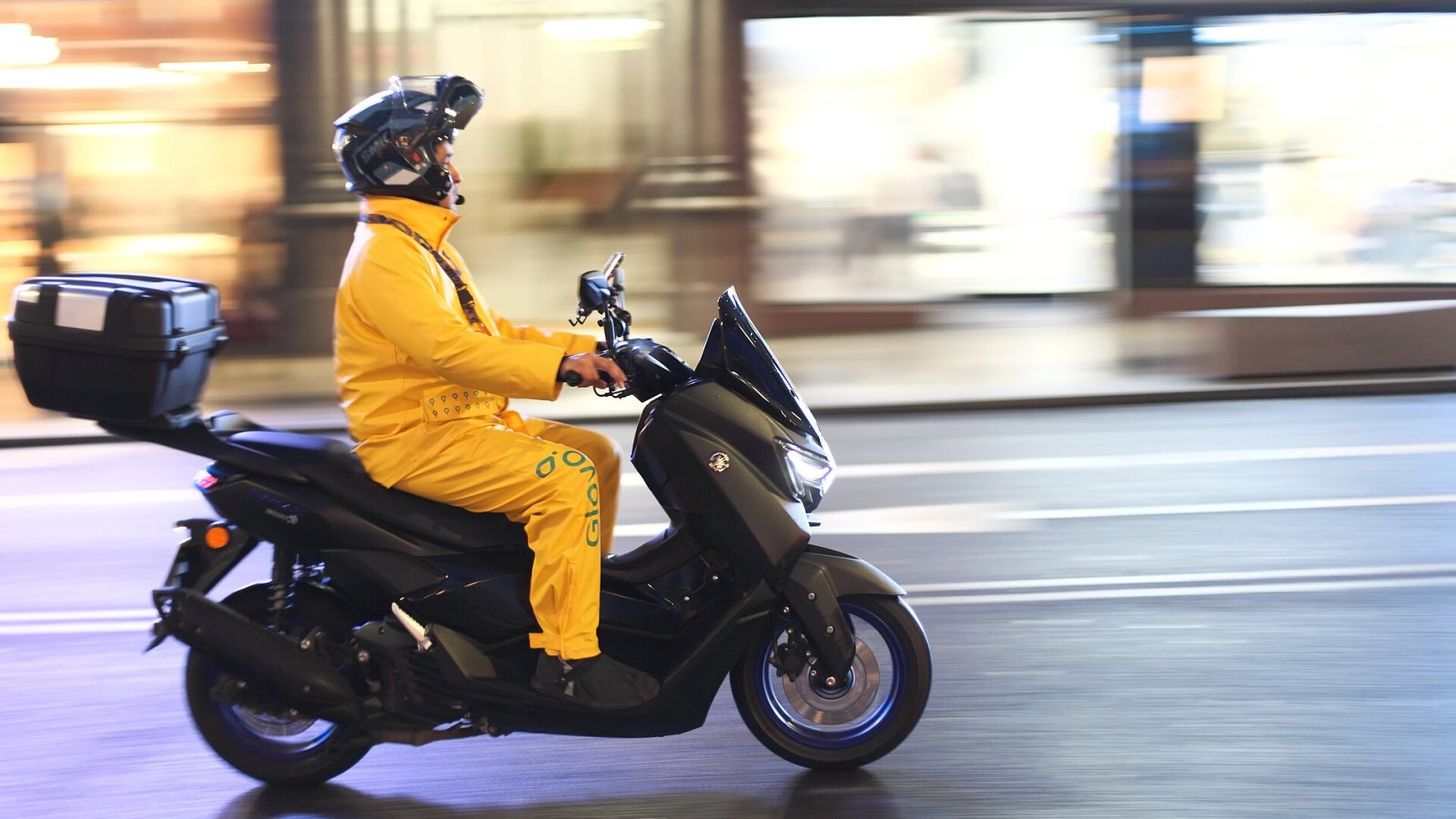 Repartidor en motocicleta con mochila de entrega